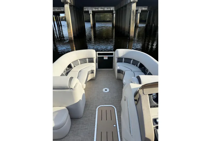 Slide: The Image of 2019 Bennington G 22 GSRFB pontoon boat interior with plush seating under a bridge. - 7