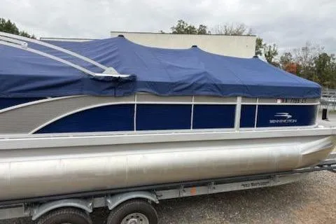 Slide: The Image of 2022 Bennington 22SXSAPG pontoon boat with blue cover on trailer. - 11