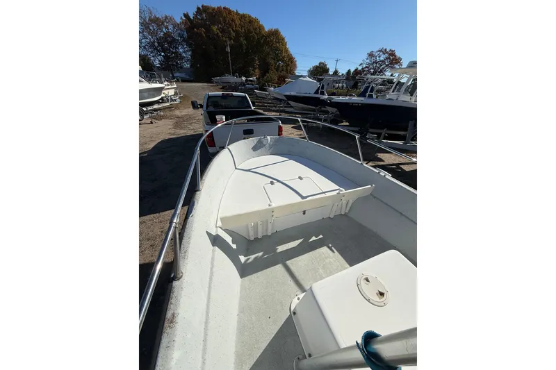 Slide: The Image of 2001 Maritime Skiff 18 boat on trailer, parked outdoors under clear blue sky. - 2
