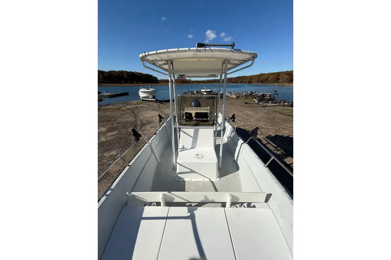 Slide: The Image of 2001 Maritime Skiff 18 boat docked by a serene lake under clear blue skies. - 3