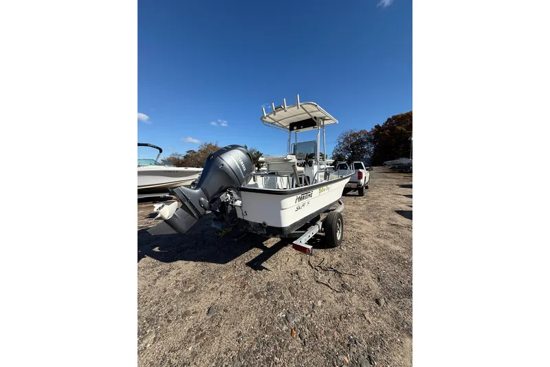 Slide: The Image of 2001 Maritime Skiff 18 boat on trailer, parked outdoors under clear blue sky. - 9