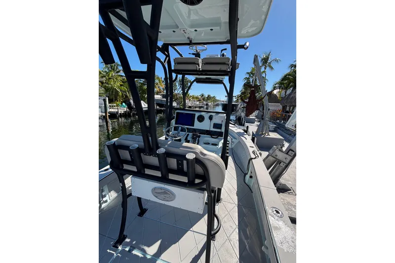 Slide: The Image of 2021 Xplor 24 Andros boat interior with steering console and seating, docked by palm trees. - 11