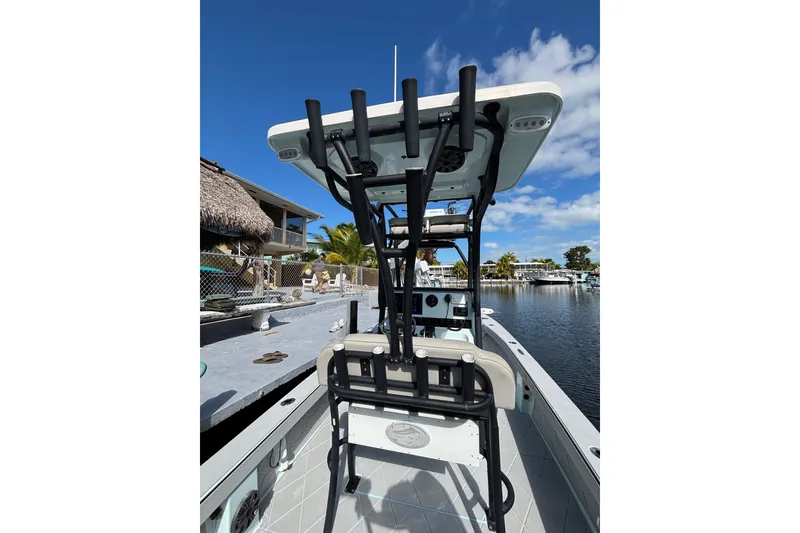 Slide: The Image of 2021 Xplor 24 Andros boat with T-top and rod holders, docked by waterfront homes. - 21