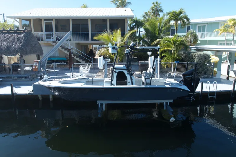 Slide: The Image of 2021 Xplor 24 Andros boat docked by a waterfront home with tropical landscaping. - 9