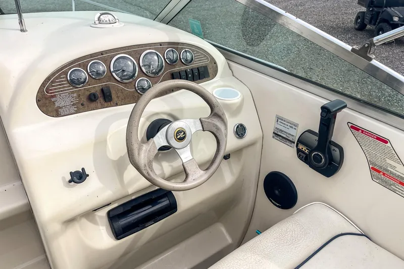 Slide: The Image of 1999 Sea Ray 215 Express Cruiser dashboard with steering wheel and control panel. - 14