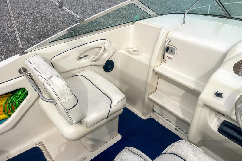 Slide: The Image of 1999 Sea Ray 215 Express Cruiser interior with white seating and blue carpet. - 16