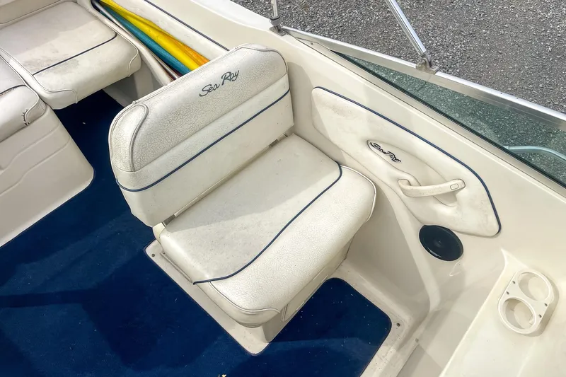 Slide: The Image of 1999 Sea Ray 215 Express Cruiser interior with white seating and blue carpet. - 18