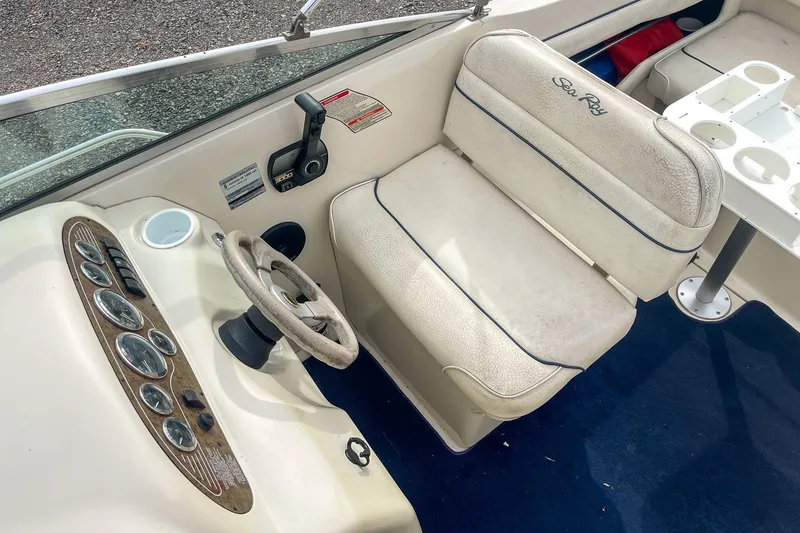 Slide: The Image of 1999 Sea Ray 215 Express Cruiser cockpit with steering wheel and seating. - 19