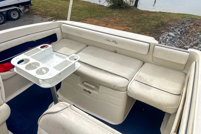 Slide: The Image of 1999 Sea Ray 215 Express Cruiser interior with seating and cup holder table. - 20