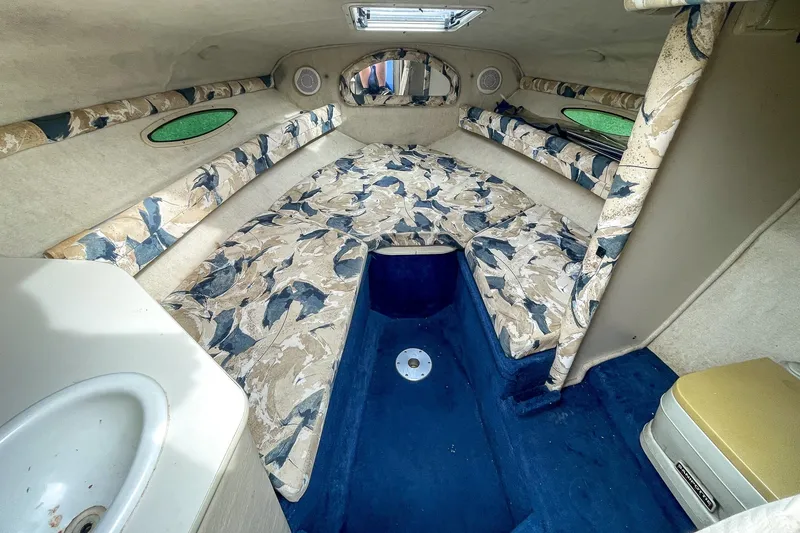 Slide: The Image of 1999 Sea Ray 215 Express Cruiser cabin interior with patterned upholstery and compact sink. - 24