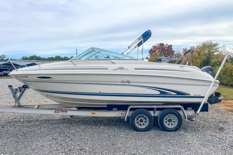 Slide: The Image of 1999 Sea Ray 215 Express Cruiser on trailer, side view, outdoors. - 5