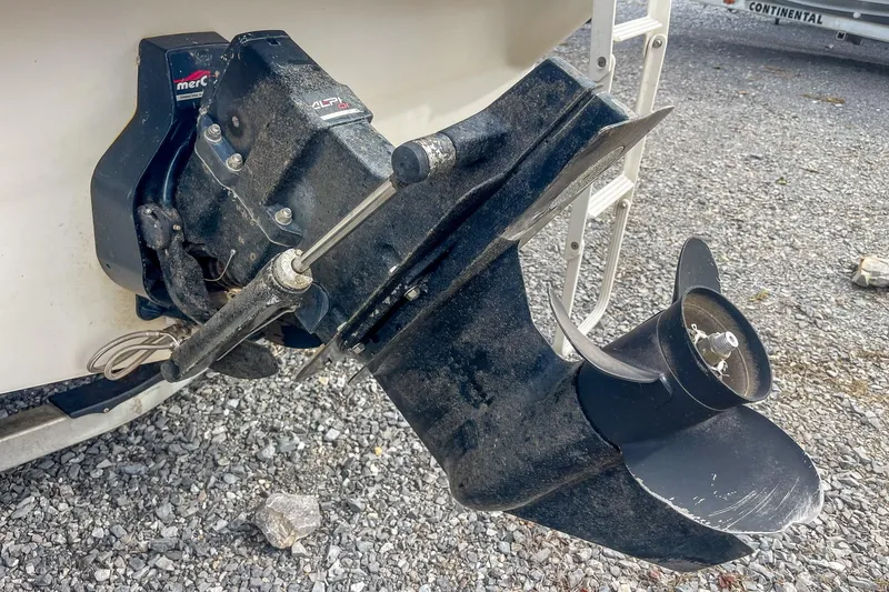 Slide: The Image of 1999 Sea Ray 215 Express Cruiser outboard motor and propeller on gravel surface. - 9