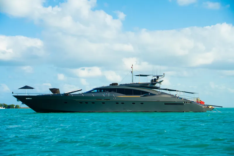 Slide: The Image of Luxurious 2003 Palmer Johnson 120 yacht cruising on turquoise waters under a partly cloudy sky. - 1