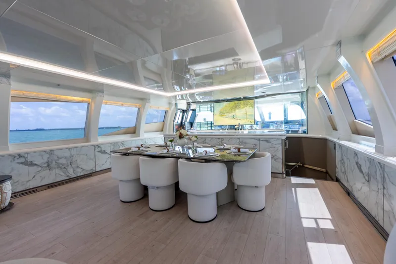 Slide: The Image of Luxurious interior of a 2003 Palmer Johnson 120 yacht with elegant dining area and panoramic windows. - 16