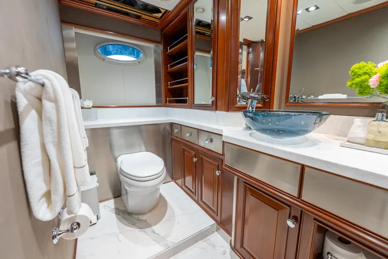 Slide: The Image of Luxurious yacht bathroom with wood cabinetry, glass sink, and modern fixtures on a 2003 Palmer Johnson 120. - 28