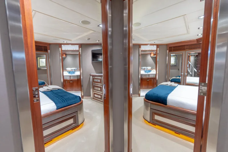 Slide: The Image of Luxurious interior of a 2003 Palmer Johnson 120 yacht with elegant wood finishes and cozy bedding. - 29