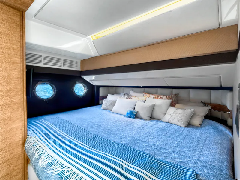 Slide: The Image of Luxurious bedroom interior of 2013 Azimut 64 yacht with blue bedding and porthole windows. - 10