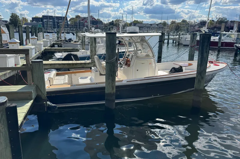 Slide: The Image of 2011 Hunt Yachts Surfhunter 25 Center Console docked at marina under cloudy sky. - 11