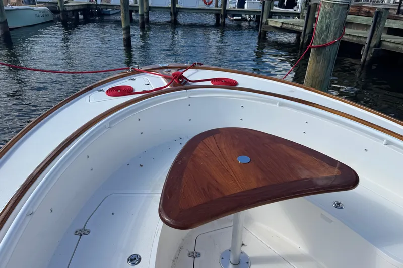 Slide: The Image of 2011 Hunt Yachts Surfhunter 25 Center Console, docked with wooden table and red ropes. - 9