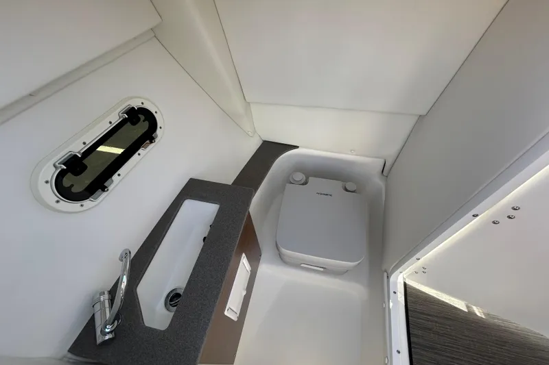 Slide: The Image of 2022 Four Winns H260 RS boat interior with compact bathroom and sink. - 22
