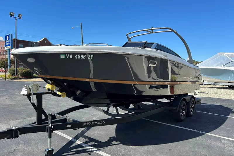 Slide: The Image of 2022 Four Winns H260 RS boat on trailer in parking lot under clear blue sky. - 26