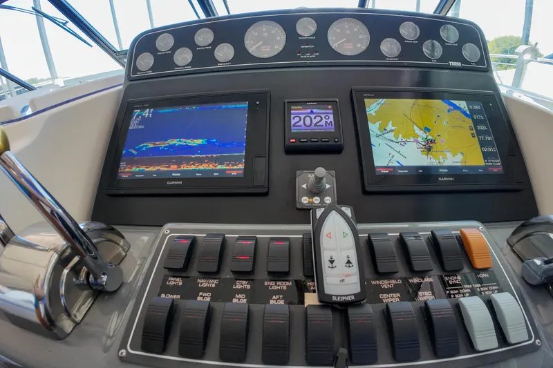 Slide: The Image of Control panel of a 1999 Tiara Yachts 3500 Express with navigation screens and switches. - 107