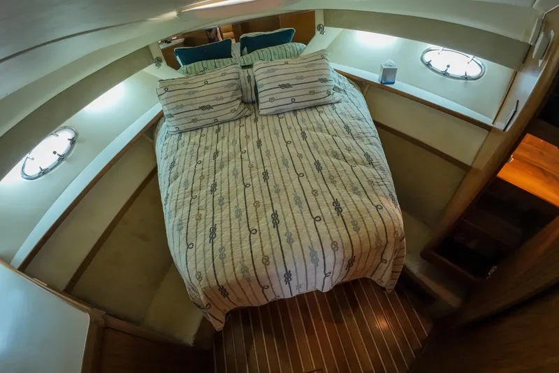 Slide: The Image of 1999 Tiara Yachts 3500 Express cabin with cozy bed and nautical decor. - 122