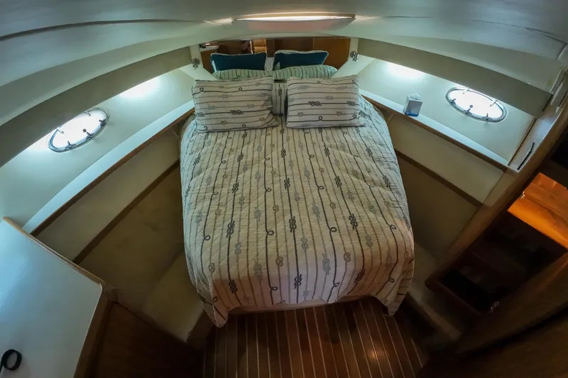 Slide: The Image of Cozy cabin interior of 1999 Tiara Yachts 3500 Express with striped bedding. - 123