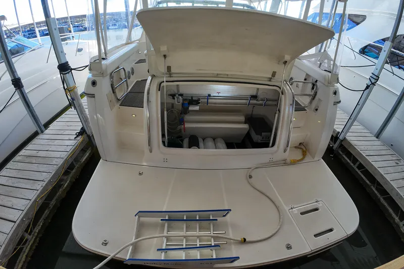 Slide: The Image of 1999 Tiara Yachts 3500 Express with open engine compartment at dockside. - 124