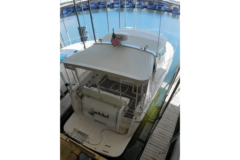 Slide: The Image of 1999 Tiara Yachts 3500 Express docked, rear view with American flag. - 129