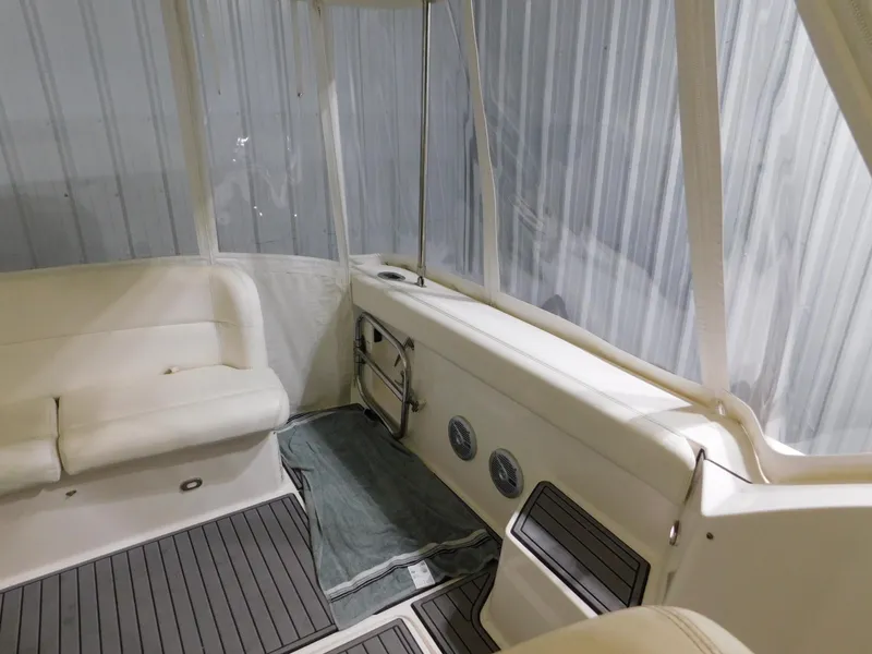 Slide: The Image of 1999 Tiara Yachts 3500 Express interior with white seating and clear enclosure. - 13