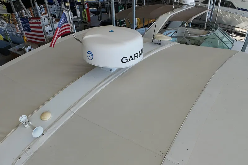 Slide: The Image of 1999 Tiara Yachts 3500 Express with Garmin radar, docked with American flags displayed. - 135