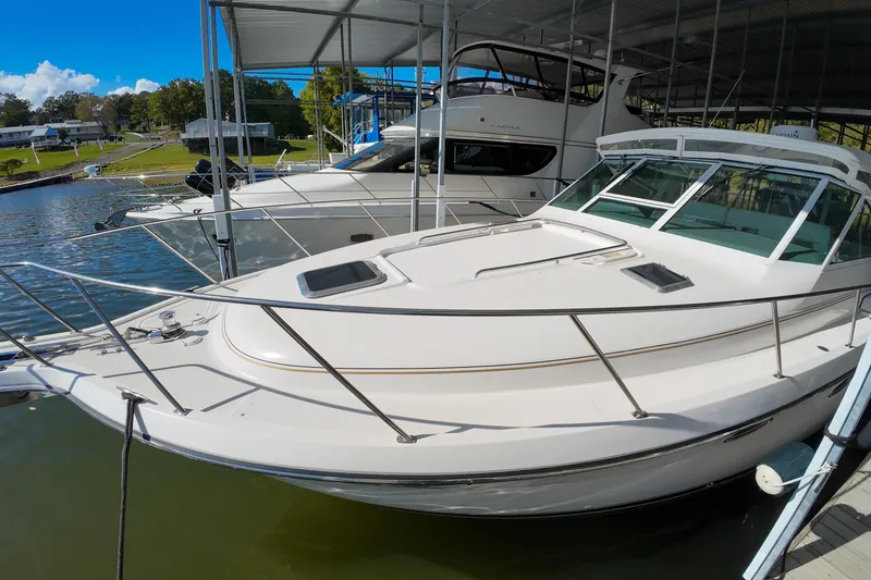 Slide: The Image of 1999 Tiara Yachts 3500 Express docked in a marina under a covered shelter. - 137