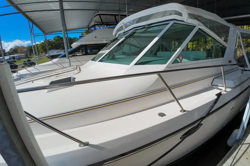 Slide: The Image of 1999 Tiara Yachts 3500 Express boat docked under a covered marina. - 139