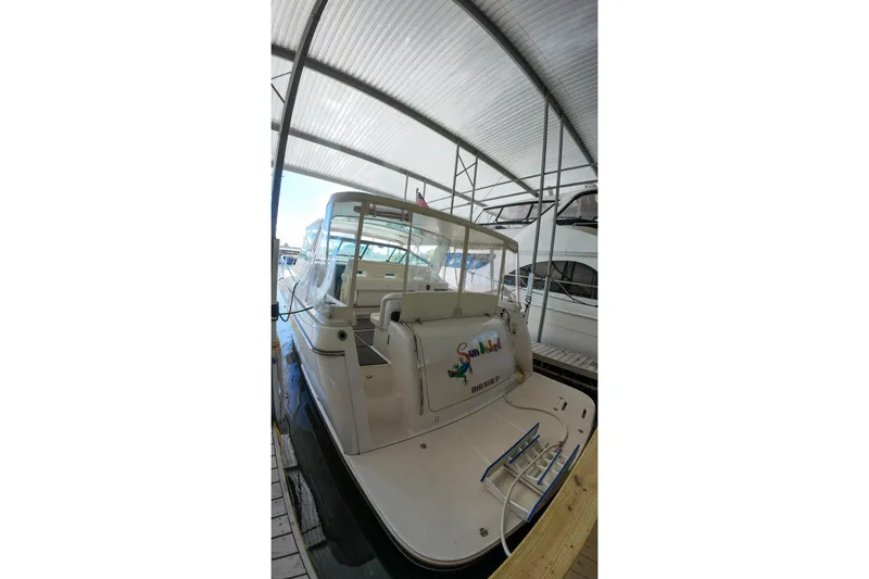 Slide: The Image of 1999 Tiara Yachts 3500 Express docked under a covered marina. - 141