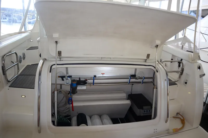 Slide: The Image of 1999 Tiara Yachts 3500 Express storage compartment with open hatch, showcasing interior equipment. - 143