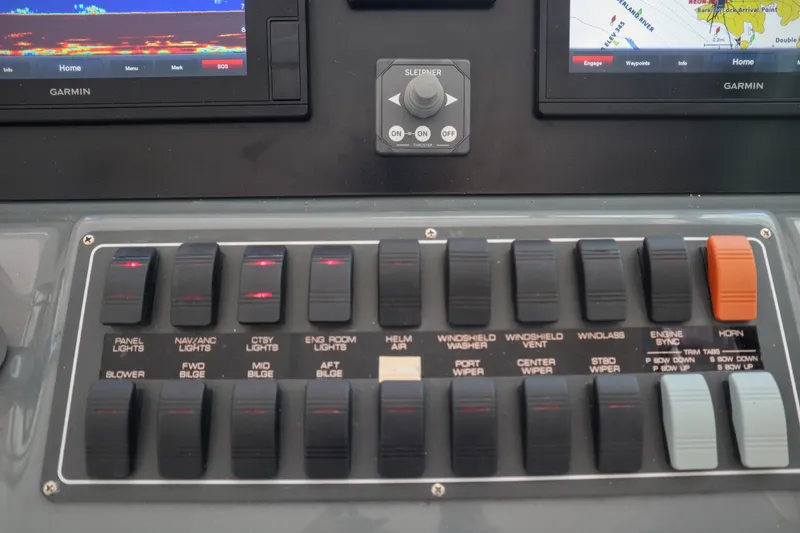 Slide: The Image of Control panel of a 1999 Tiara Yachts 3500 Express with various switches and Garmin displays. - 151