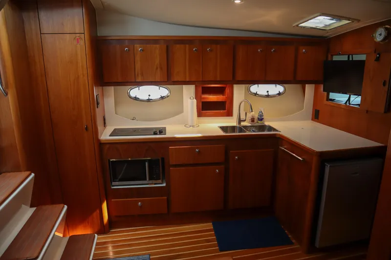 Slide: The Image of 1999 Tiara Yachts 3500 Express interior kitchen with wood cabinetry and modern appliances. - 154