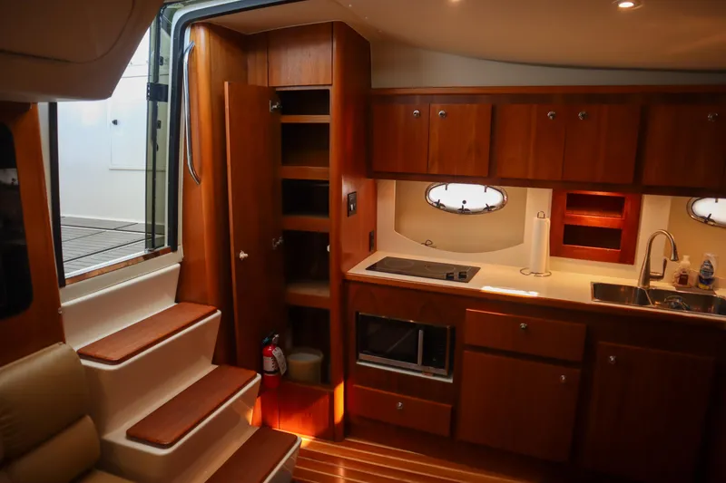 Slide: The Image of 1999 Tiara Yachts 3500 Express interior with wooden cabinetry and modern kitchen amenities. - 156