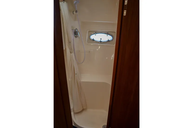 Slide: The Image of Shower area in 1999 Tiara Yachts 3500 Express, featuring a compact design and porthole window. - 160