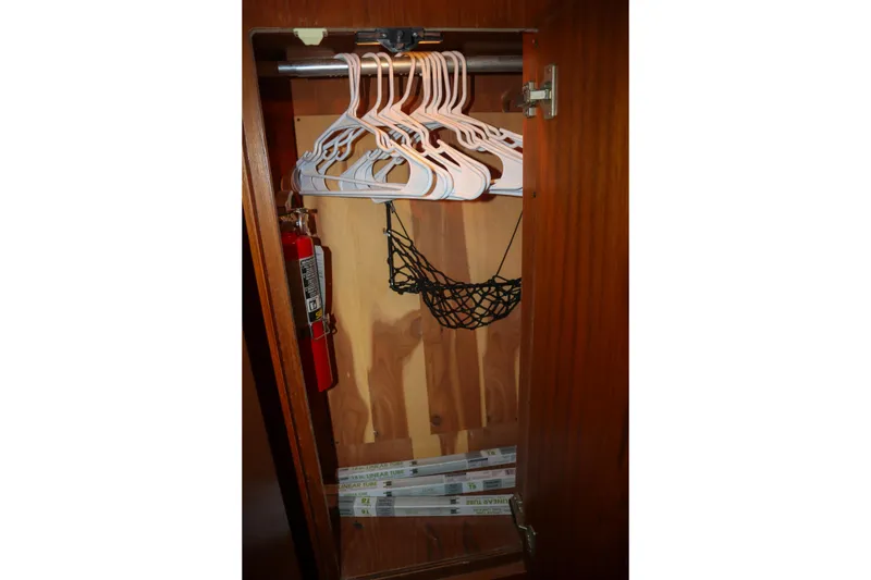 Slide: The Image of 1999 Tiara Yachts 3500 Express closet with hangers, fire extinguisher, and storage net. - 163