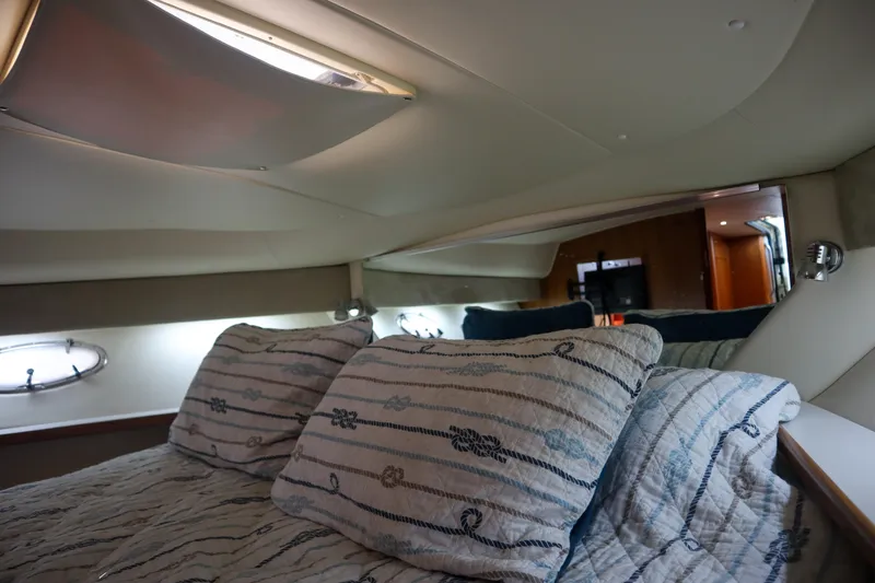 Slide: The Image of 1999 Tiara Yachts 3500 Express cabin interior with cozy bedding and ambient lighting. - 166