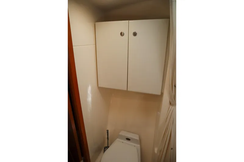 Slide: The Image of Bathroom interior of 1999 Tiara Yachts 3500 Express with white cabinets. - 167