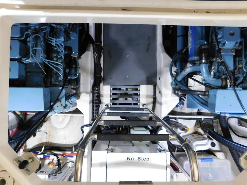 Slide: The Image of Engine room of a 1999 Tiara Yachts 3500 Express, featuring dual blue engines. - 18