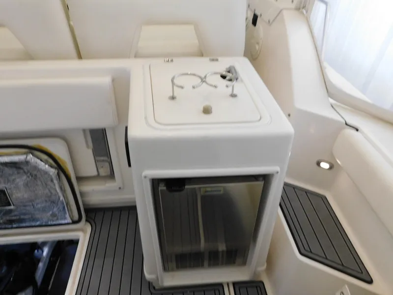 Slide: The Image of 1999 Tiara Yachts 3500 Express interior with compact fridge and storage area. - 19