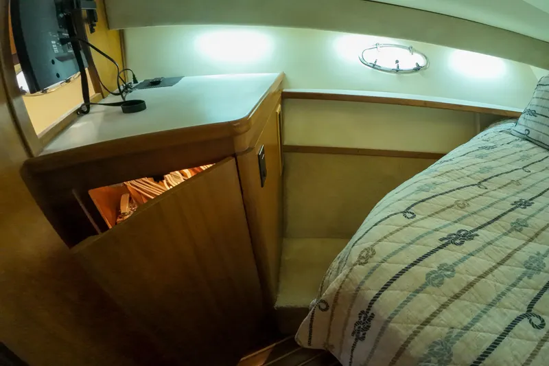 Slide: The Image of 1999 Tiara Yachts 3500 Express cabin interior with bed and storage cabinet. - 202