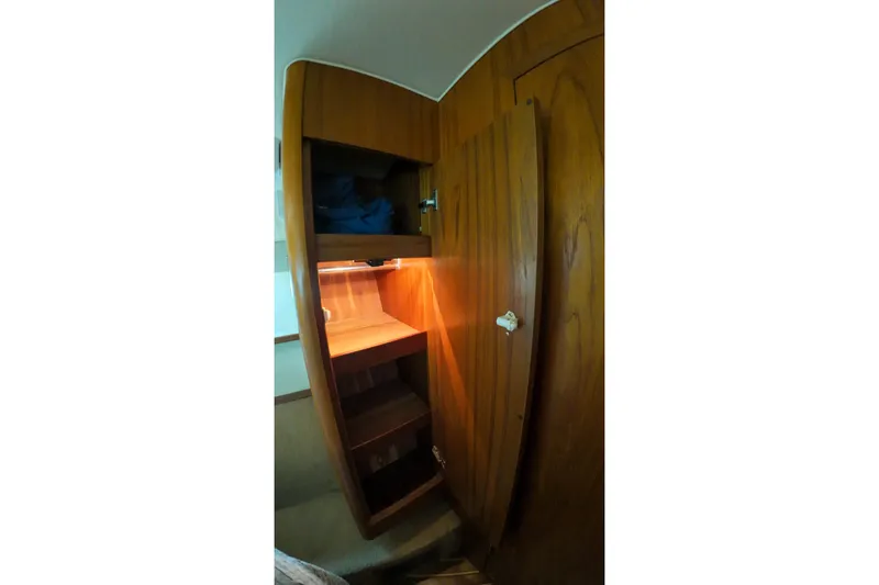 Slide: The Image of 1999 Tiara Yachts 3500 Express interior wooden cabinet with shelves and lighting. - 203