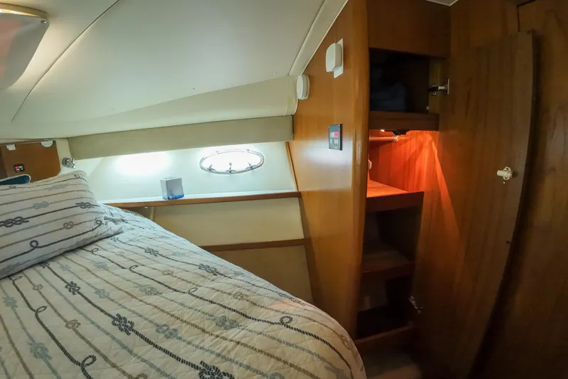 Slide: The Image of 1999 Tiara Yachts 3500 Express cabin interior with bed and wooden storage. - 204