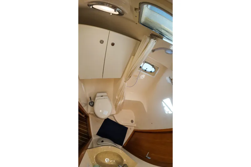 Slide: The Image of 1999 Tiara Yachts 3500 Express bathroom interior with shower, sink, and toilet. - 209