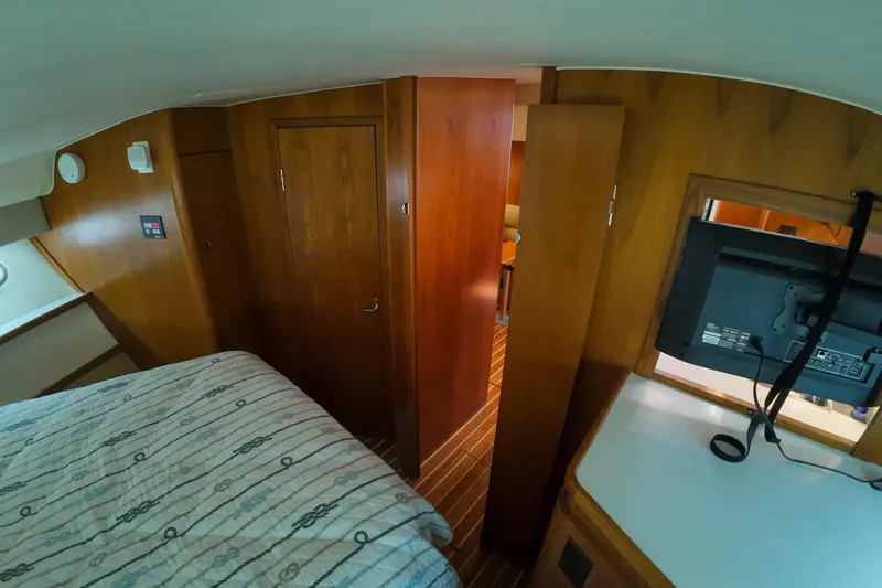Slide: The Image of 1999 Tiara Yachts 3500 Express cabin interior with wood paneling and TV. - 214